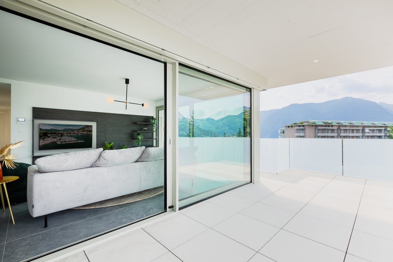 A stylish modern living space with a balcony offering a scenic mountain view.